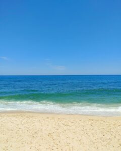 a view of the ocean from a sandy beach